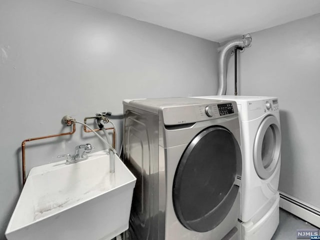 washroom with independent washer and dryer, sink, and a baseboard heating unit