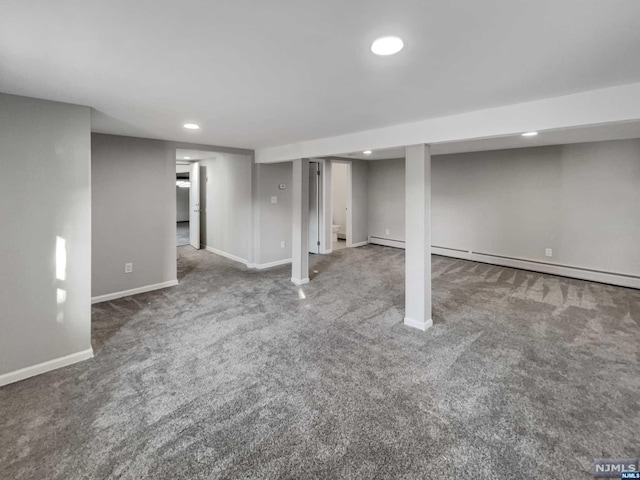 basement featuring carpet flooring and a baseboard heating unit