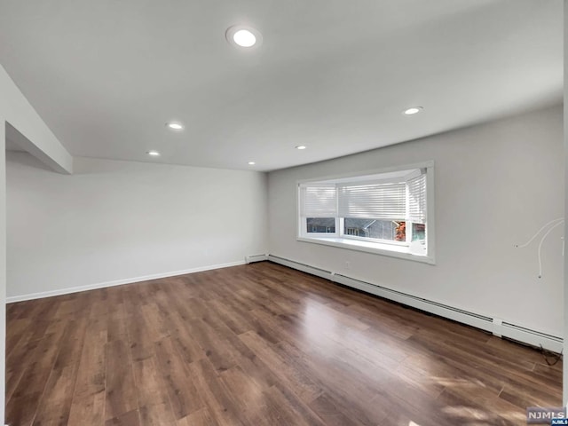 spare room featuring dark hardwood / wood-style flooring and a baseboard radiator