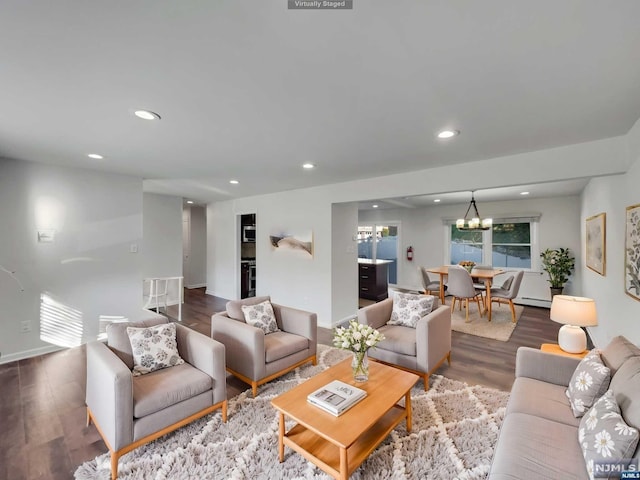 living room featuring hardwood / wood-style flooring, an inviting chandelier, and a baseboard heating unit