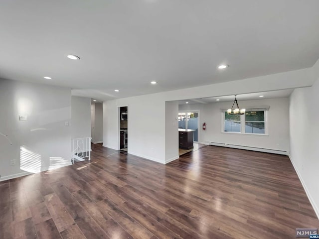 unfurnished living room with a chandelier, dark hardwood / wood-style floors, and a baseboard heating unit