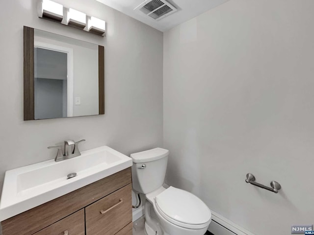 bathroom featuring vanity, a baseboard radiator, and toilet