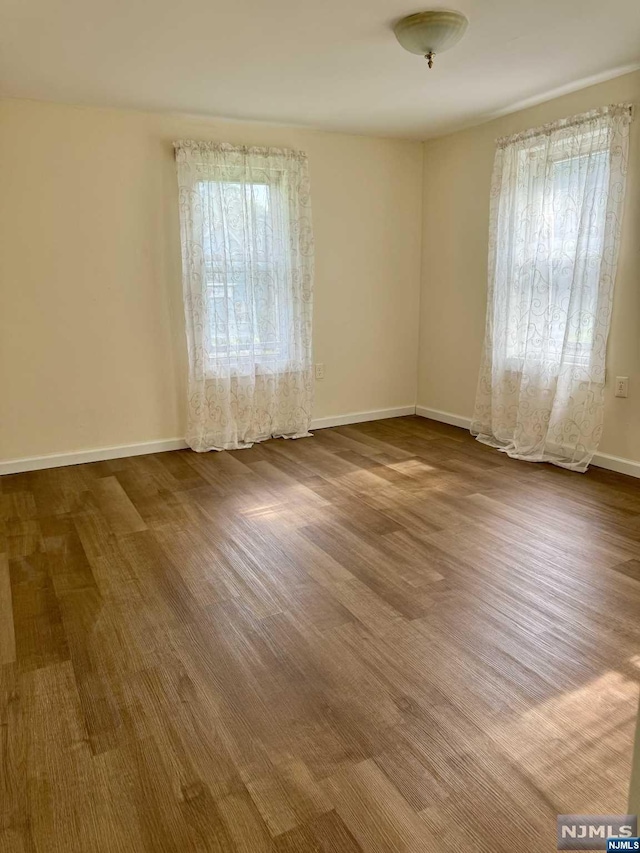 unfurnished room with hardwood / wood-style floors