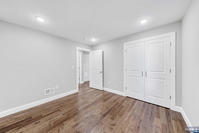 unfurnished bedroom featuring dark hardwood / wood-style floors and a closet