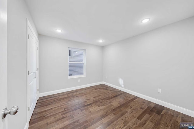 unfurnished room with dark hardwood / wood-style flooring