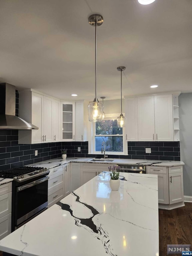 kitchen featuring gas range, sink, wall chimney range hood, dark hardwood / wood-style floors, and white cabinets