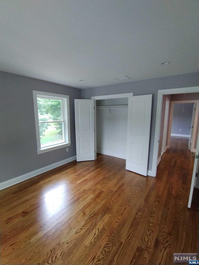 unfurnished bedroom featuring hardwood / wood-style flooring and a closet