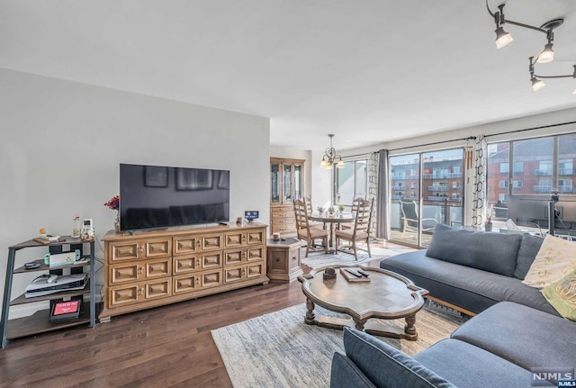 living room featuring dark hardwood / wood-style flooring, a healthy amount of sunlight, and a notable chandelier