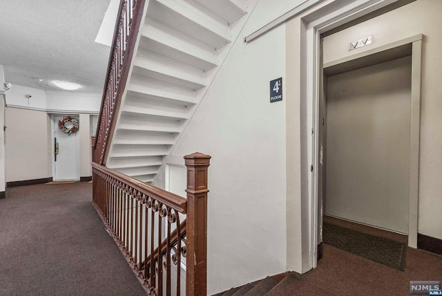 corridor featuring dark carpet and a textured ceiling