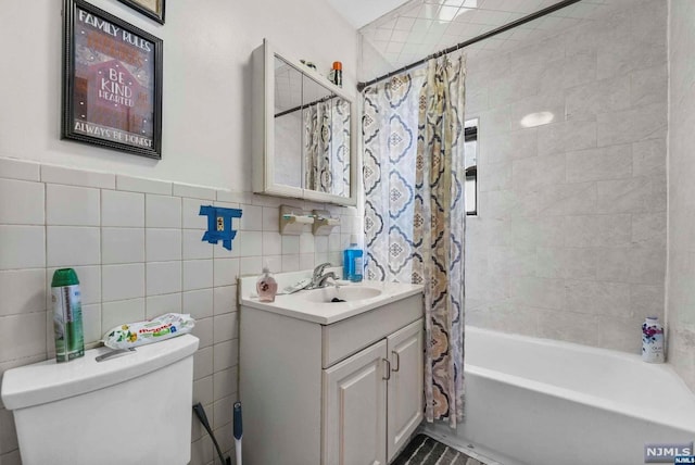 full bathroom with shower / tub combo, vanity, toilet, and tile walls