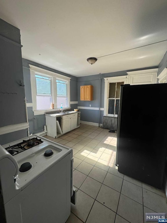 kitchen with white range with gas cooktop and light tile patterned floors