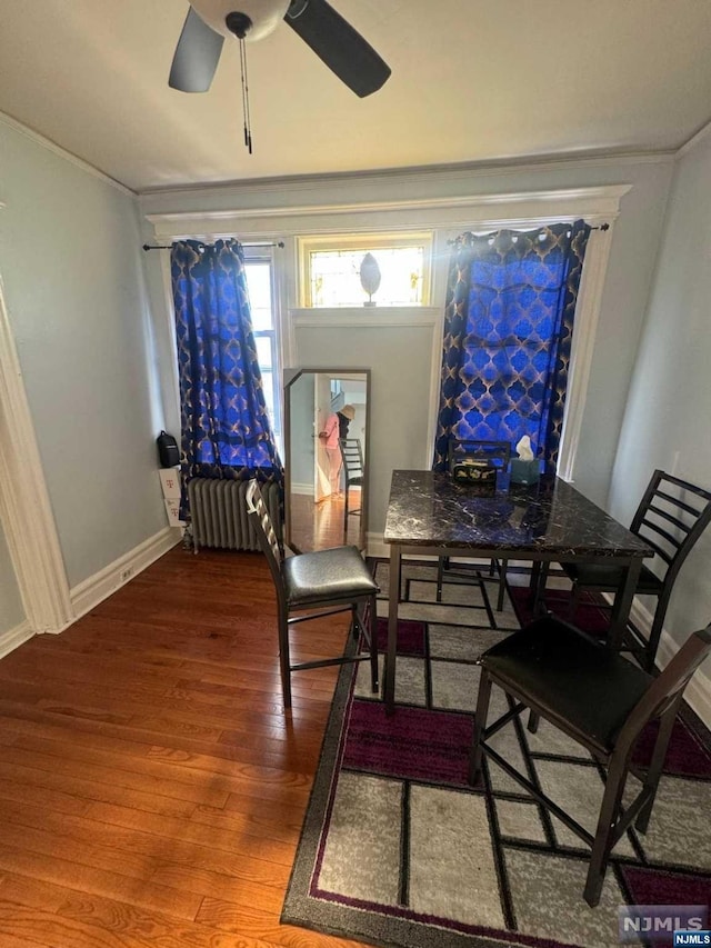 dining room featuring radiator heating unit, hardwood / wood-style flooring, ceiling fan, and ornamental molding