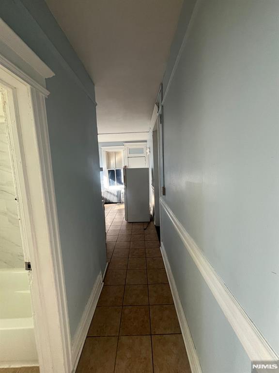 hall featuring dark tile patterned flooring