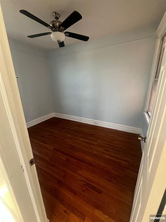 spare room with ceiling fan and dark hardwood / wood-style flooring