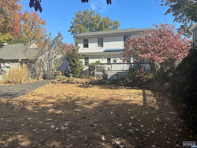 rear view of house featuring a wooden deck