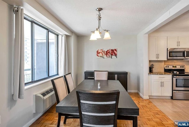 dining space with an inviting chandelier, a textured ceiling, and a wall mounted air conditioner