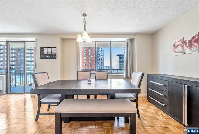 dining area with a textured ceiling and light parquet flooring