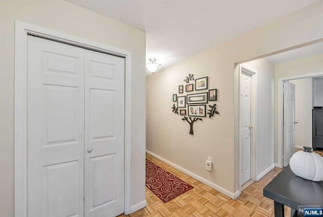 hallway featuring a textured ceiling and light parquet floors