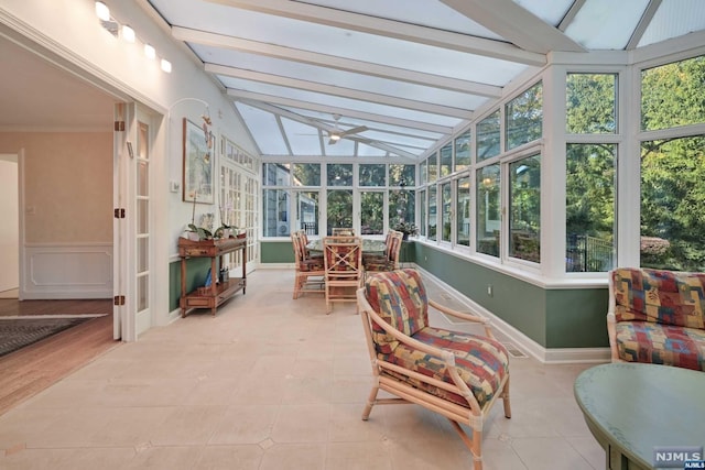 sunroom with lofted ceiling with beams and ceiling fan