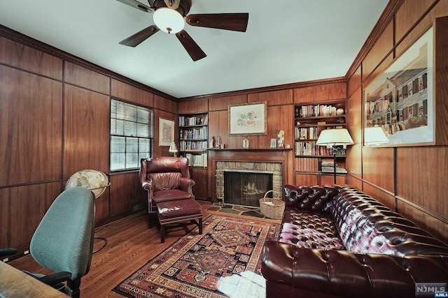 living room featuring wooden walls, a fireplace, and dark hardwood / wood-style floors