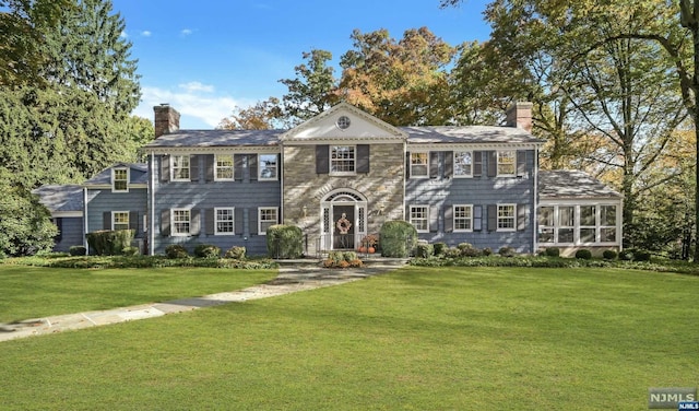 colonial house featuring a front yard