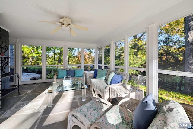 sunroom / solarium featuring plenty of natural light and ceiling fan