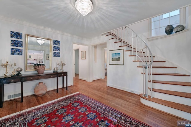 entryway featuring hardwood / wood-style flooring and a notable chandelier