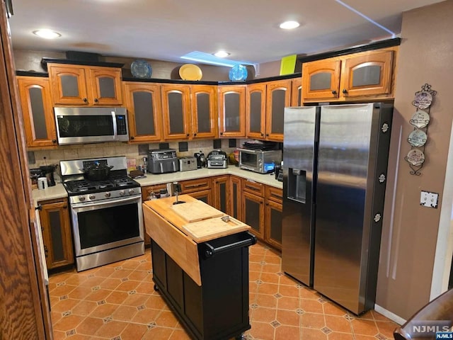 kitchen featuring backsplash, a kitchen island, and stainless steel appliances