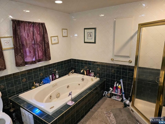 bathroom featuring tile walls and independent shower and bath