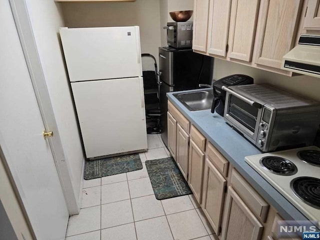 kitchen with light tile patterned floors, white appliances, sink, and range hood