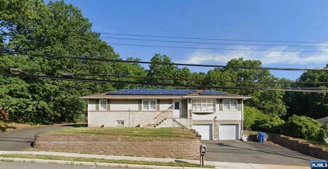 view of front of house featuring solar panels and a garage