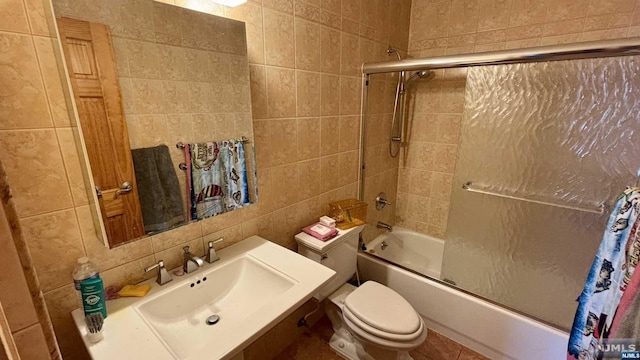 full bathroom with toilet, shower / bath combination with glass door, sink, and tile walls