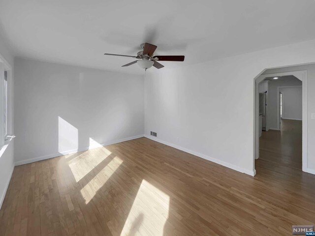 empty room featuring ceiling fan and dark hardwood / wood-style flooring