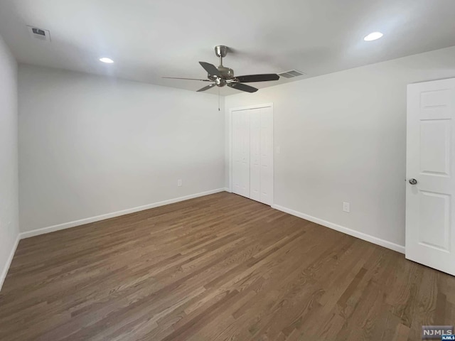 spare room with dark hardwood / wood-style floors and ceiling fan