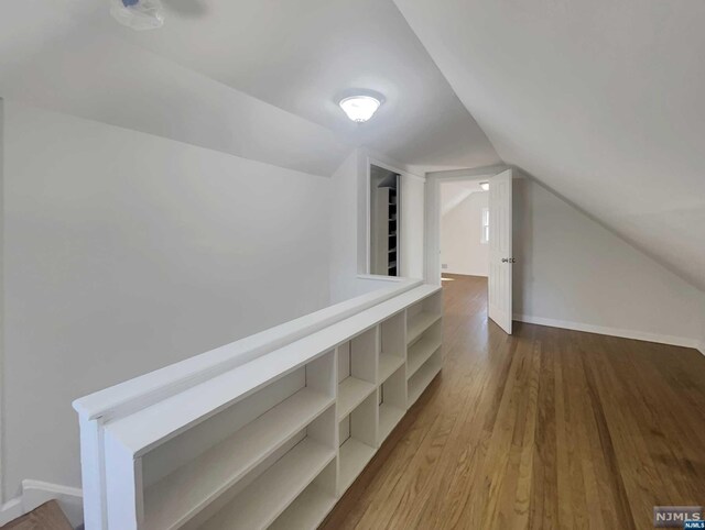 hallway featuring lofted ceiling and hardwood / wood-style flooring