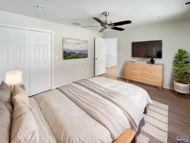 bedroom with ceiling fan, a closet, and hardwood / wood-style flooring