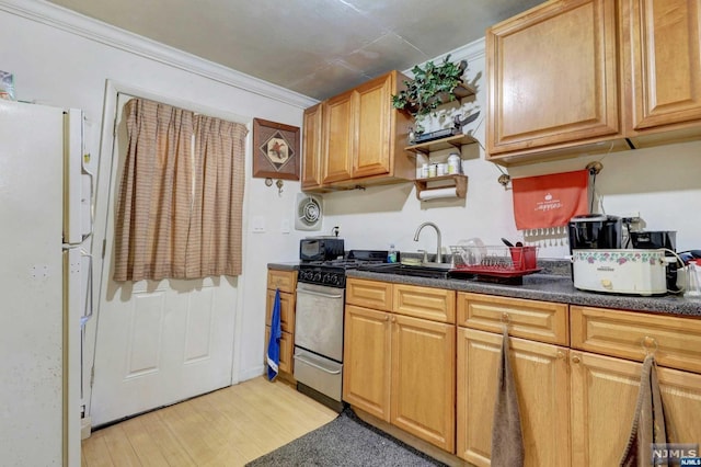 kitchen featuring light wood-type flooring, gas range, crown molding, sink, and white fridge