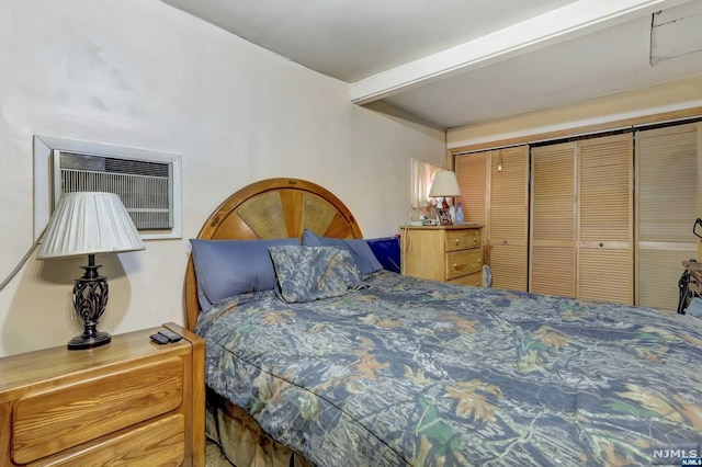 bedroom with beamed ceiling, a wall unit AC, and a closet