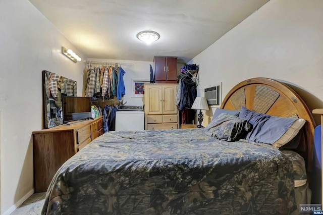 bedroom with an AC wall unit and washer / dryer