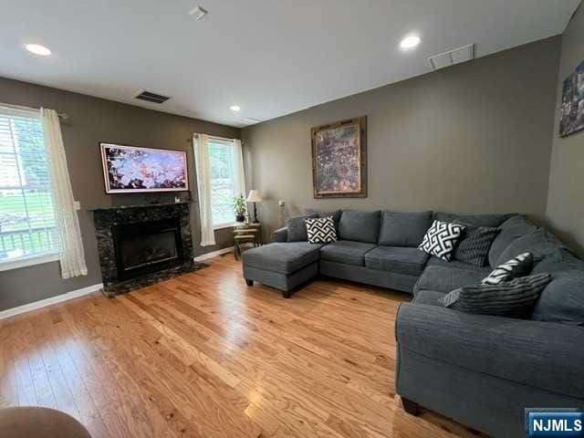 living room with light hardwood / wood-style floors and a high end fireplace