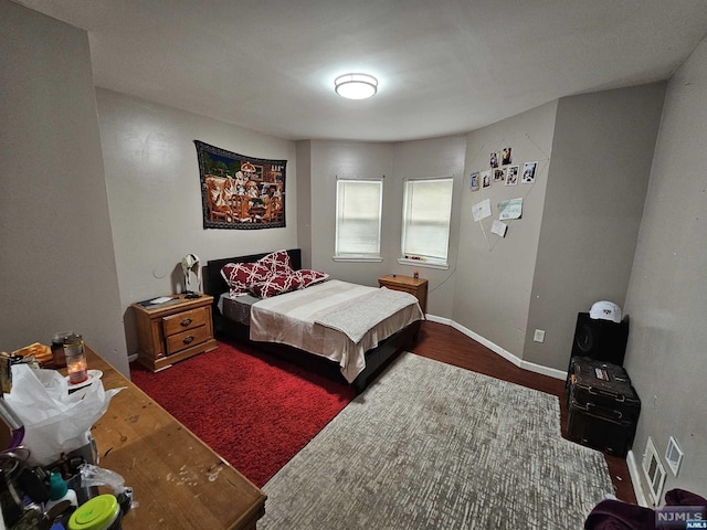 bedroom with dark hardwood / wood-style flooring