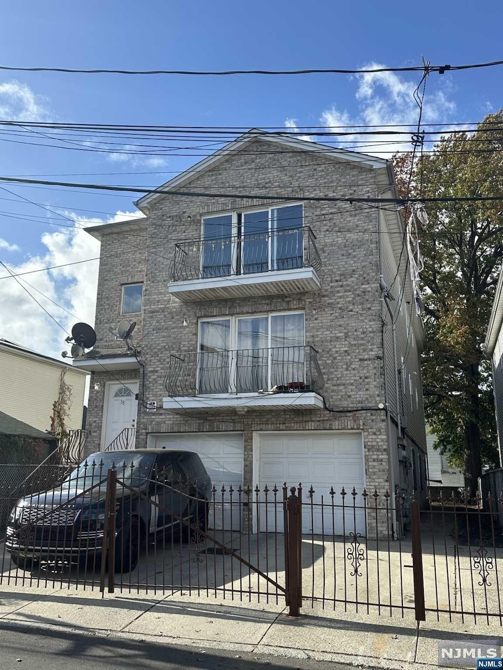 view of front of home with a garage and a balcony