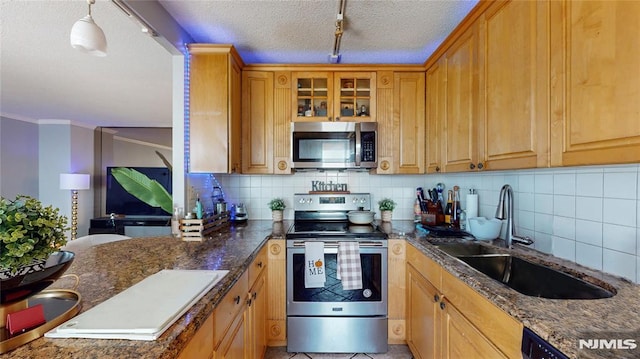 200 Winston Dr Unit 418, Cliffside Park, NJ 07010 - kitchen with appliances with stainless steel finishes, backsplash, track lighting, a textured ceiling, and glass insert cabinets