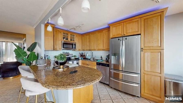 200 Winston Dr Unit 418, Cliffside Park, NJ 07010 - kitchen with appliances with stainless steel finishes, light tile patterned floors, stone countertops, tasteful backsplash, and a kitchen bar