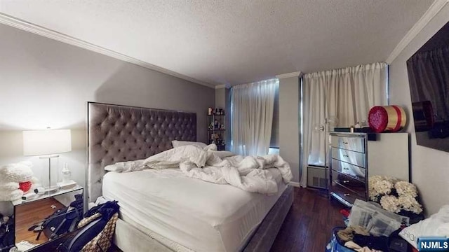 bedroom featuring ornamental molding, a textured ceiling, and dark wood-type flooring