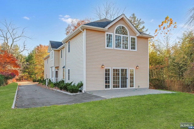 back of property with a patio and a lawn