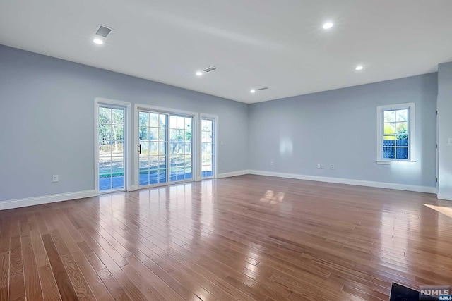 spare room with hardwood / wood-style flooring and a healthy amount of sunlight