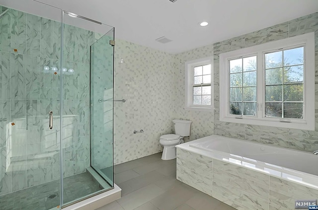 bathroom with tile patterned flooring, separate shower and tub, and toilet