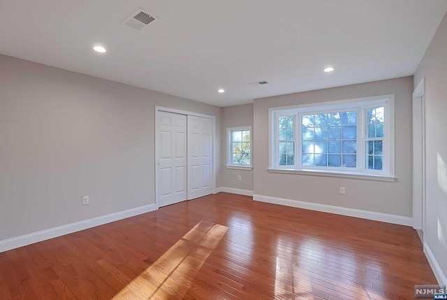 unfurnished bedroom featuring hardwood / wood-style flooring and a closet