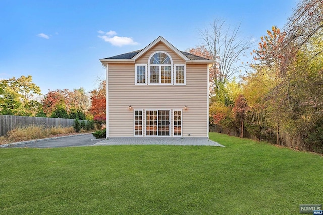 back of property with a patio area and a lawn